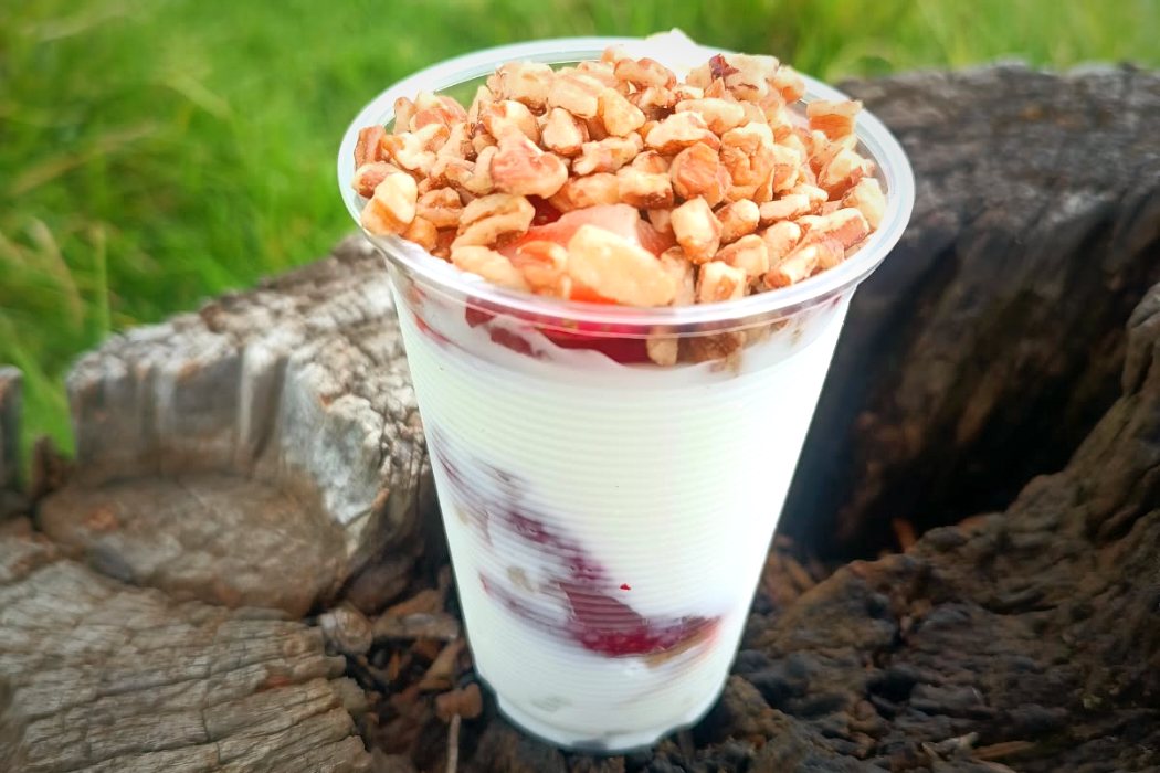 Vaso de yogurt griego con nuez y almendra